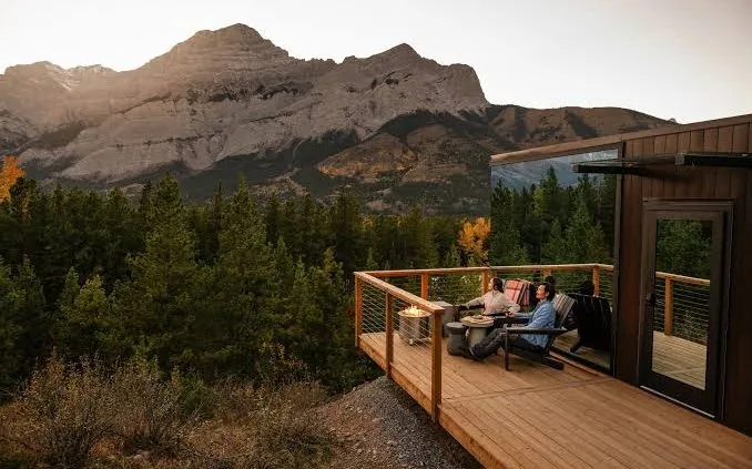 Guests on the deck of a Posh Outdoors glamping cabin