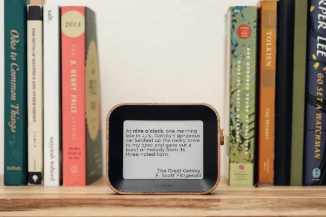The Author Clock on a shelf in front of a row of novels, telling the time with a line from The Great Gatsby