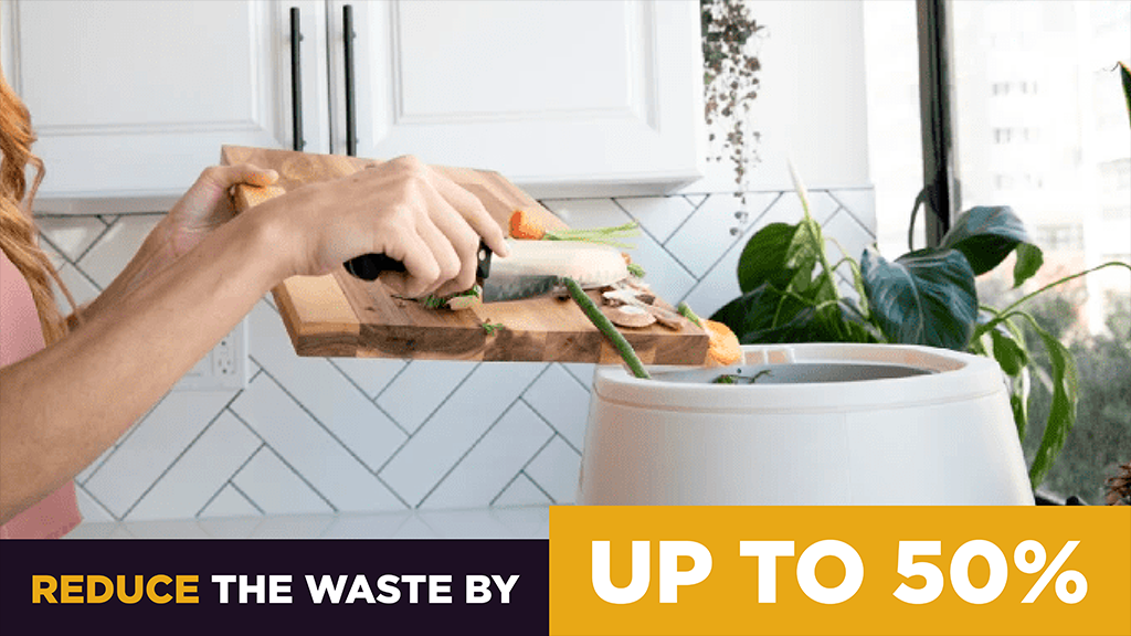 A close up shot of someone filing the Lomi with food waste from a cutting board. A caption at the bottom of the image reads "Reduce waste by up to 50%"