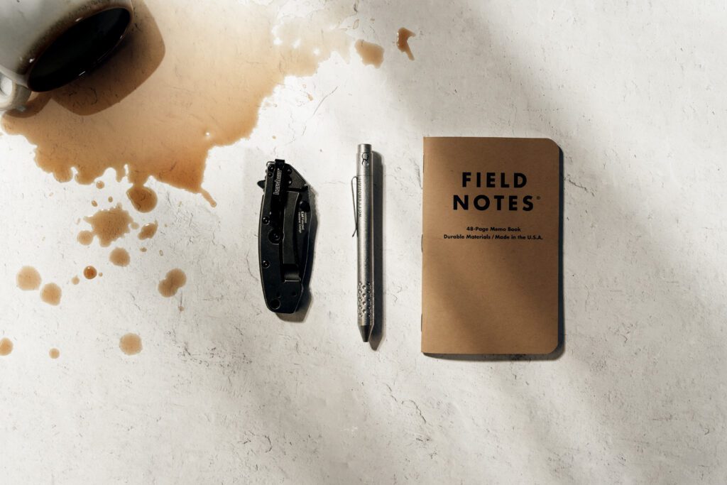 coffee, pocket knife, pen, and notebook