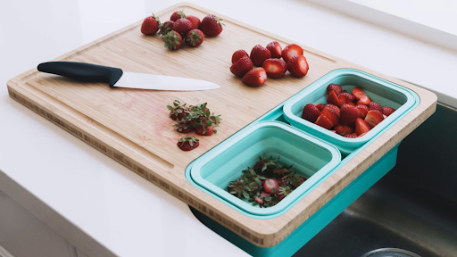 An image of a Tidyboard cutting board with carious fruits and a knife on it.
