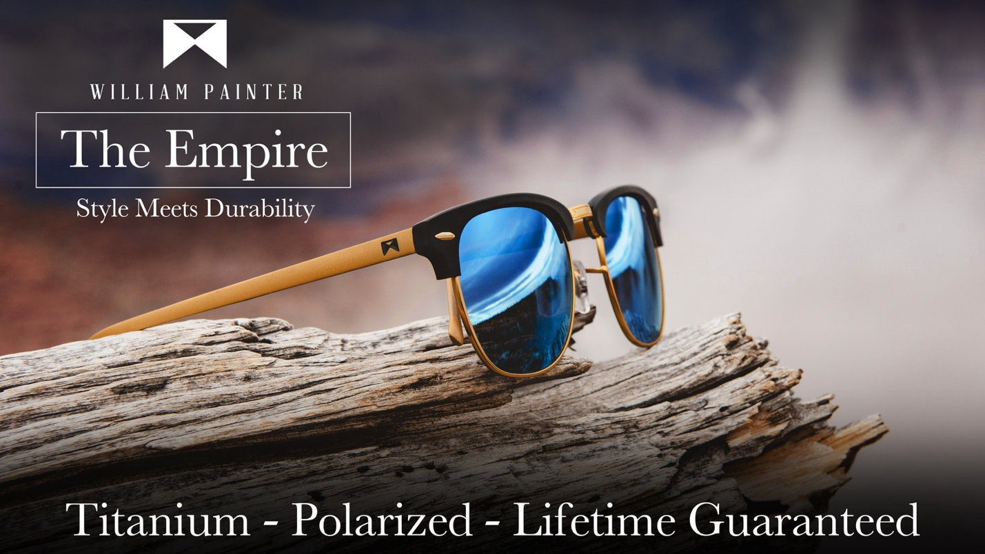 A close up of the Empire sunglasses by William Painter sitting on driftwood. The text on the image reads Titanium - Polarized -Lifetime Guaranteed.