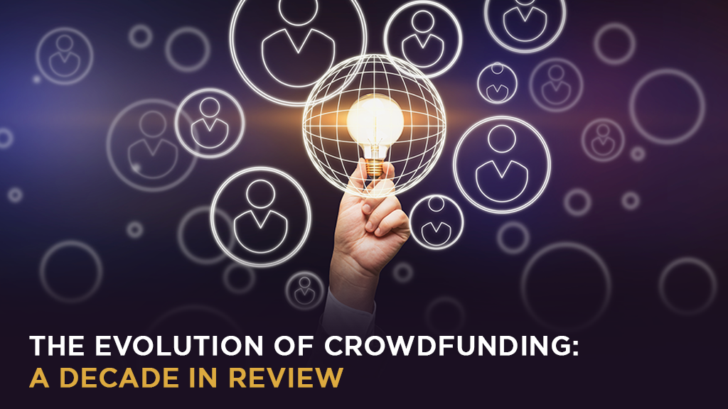 A hand holding a lit lightbulb over the words The Evolution of Crowdfunding: A Decade in Review.